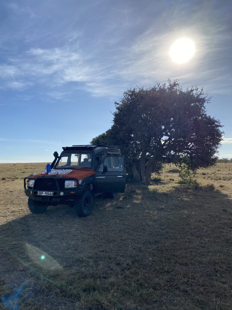 Jeep in masai mara with sunrise as part of luxury hotel stay